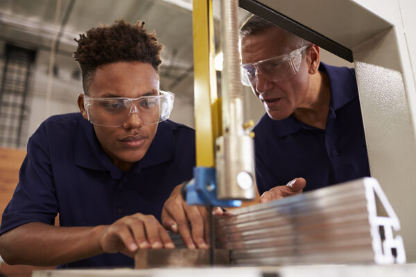 Young man learning how to use mechanized saw